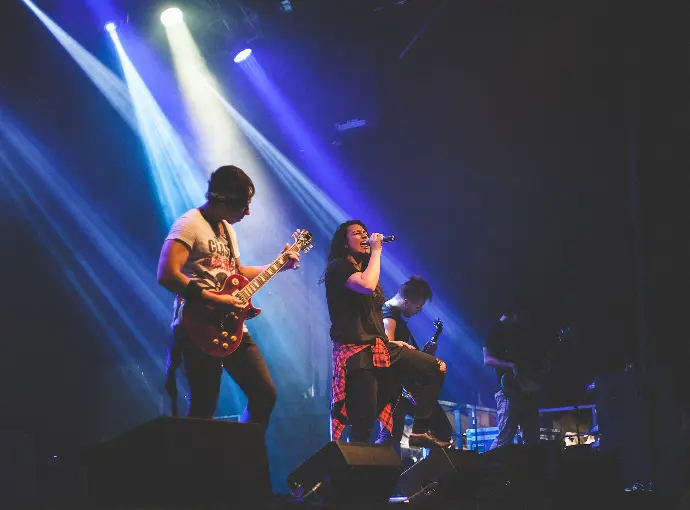 photo of male band performing on stadium